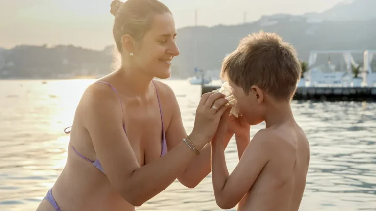 smiling mother putting on snorkeling mask on her l 2023 11 27 05 32 35 utc